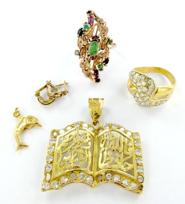 une photo présentant une collection de bijoux comprenant un livre, une bague et un pendentif
