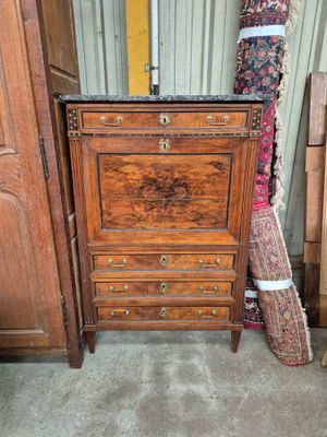 a small chest of drawers in a room next to a door