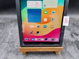 une image représentant une tablette posée sur un support en bois