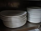 beaucoup d'assiettes sur une étagère dans une cuisine