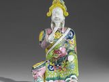 une figurine orientale représentant une femme vêtue d'une tenue verte et jaune
