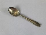 a silver spoon with a diamond on it sitting on a table