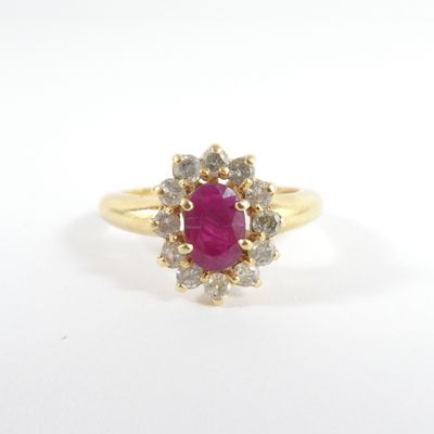 une bague en or sertie d'un rubis entouré de diamants blancs