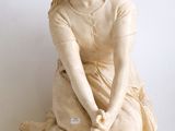 une statue de femme assise sur une table