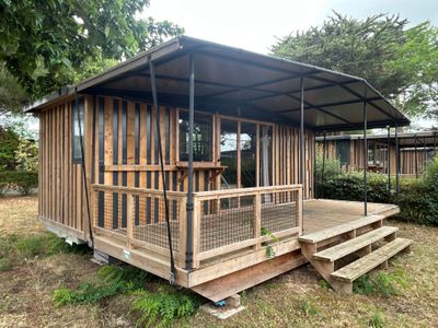 a small wooden house with a porch and a covered porch