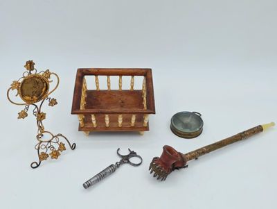 une petite boîte en bois contenant une clé, un bougeoir et une paire de ciseaux