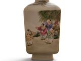 a small vase with a painting on it on a white surface
