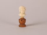 un buste antique en ivoire sculpté représentant une femme, posé sur un socle en bois