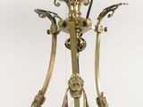 a green glass vase with a gold handle on a stand