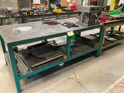 un établi au milieu d'une usine, sur lequel sont posés de nombreux outils