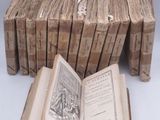 several old books are stacked on top of each other on a table