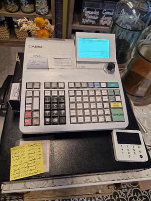 une calculatrice posée sur une table sur laquelle se trouvent des notes
