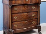 une petite commode dans le coin d'une pièce
