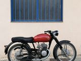 a red motorcycle parked in front of a building with a blue window