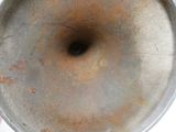 une casserole en métal percée d'un trou, posée sur une table