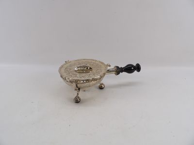 a small silver plate with a black handle on a white surface