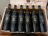 six bottles of wine in a wooden box on a table