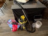 une photo d'une pièce où l'on voit un aspirateur et d'autres objets posés par terre