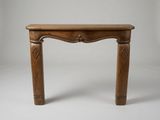 une petite table en bois dont le plateau est sculpté sur fond blanc