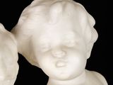 two white statues of a boy and a girl on a black background