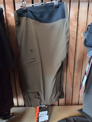 a pair of pants and a pair of skis hanging on a rack