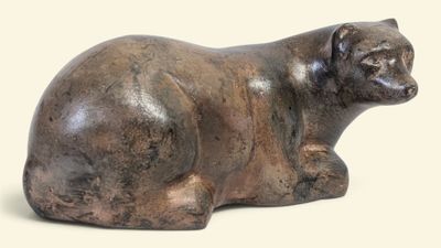 une statue représentant un ours assis par terre