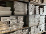Des cartons de différentes tailles et couleurs sont empilés sur une étagère dans un entrepôt