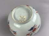a white bowl with a red and blue design on it