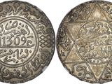 a silver coin with arabic writing on it
