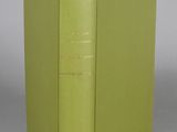 an open book with a green cover sitting on top of a table