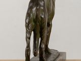 statue of a dog standing on a marble base on a table