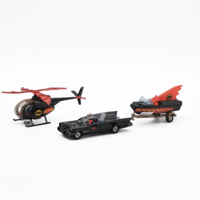 two toy cars and a helicopter on a white surface
