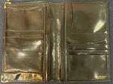 a black leather wallet with a gold clasp on the front
