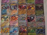 a pile of pokemon cards sitting on top of a white sheet