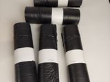 quatre rouleaux de papier noir et blanc posés sur une table blanche