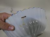 a hand that is holding a white bowl with a hole in it