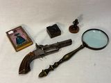 un pistolet, une loupe et une photo posés sur une table