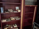 a red bookcase with many books on it in a room