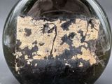 a glass vase with a brown and black design on it