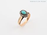un gros plan d'une bague en or avec une pierre turquoise au centre