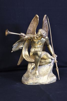bronze statue of a woman sitting on a rock with a bow and arrow