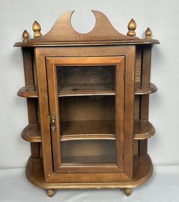 une armoire en bois avec une porte vitrée et des étagères