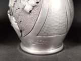 a silver vase that has a picture of a man on it