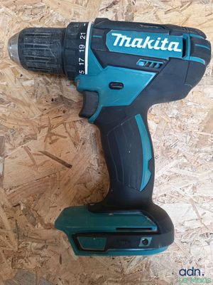a close up of a cordless drill on a piece of wood