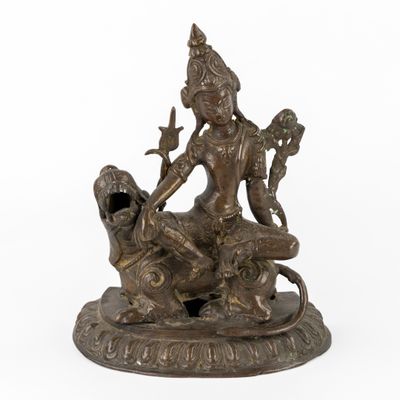 une statue en bronze représentant une femme assise sur un lion