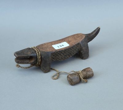 une vieille figurine en bois représentant un chien, avec une corde autour du cou