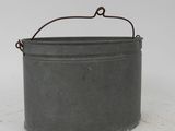 an old metal bucket sitting on top of a white surface