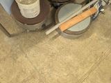 a person standing on the floor next to a bucket of paint and a pair of shoes