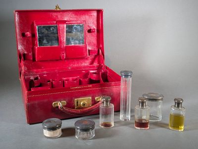 a red suitcase that has a lot of bottles inside of it