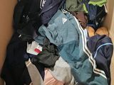 a cardboard box filled with clothes and a cat